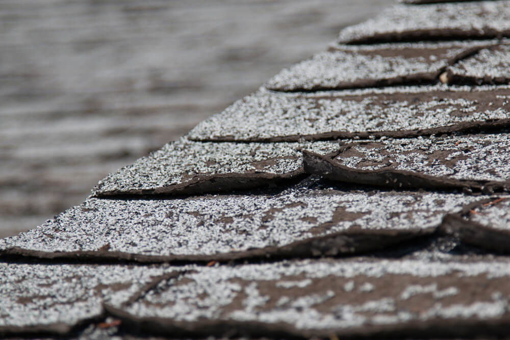 Close up of a roof top with curling shingles