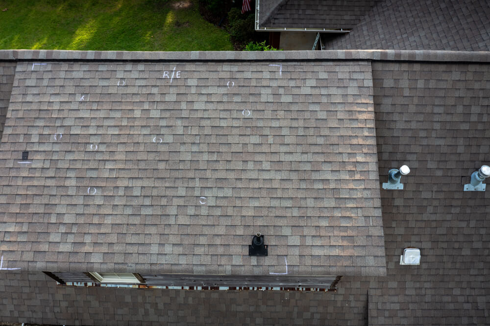 rooftop with inspection markings showing hail damage