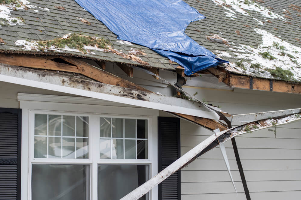 Blue tarp covering a roof's storm damage