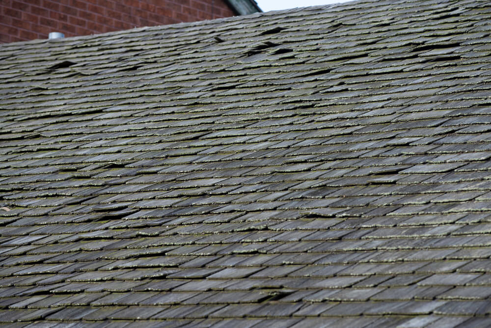 an old roof with missing and curling shingles
