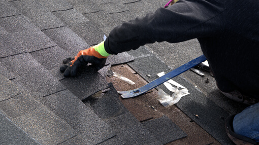 Roofer making some repairs to roofing shingles