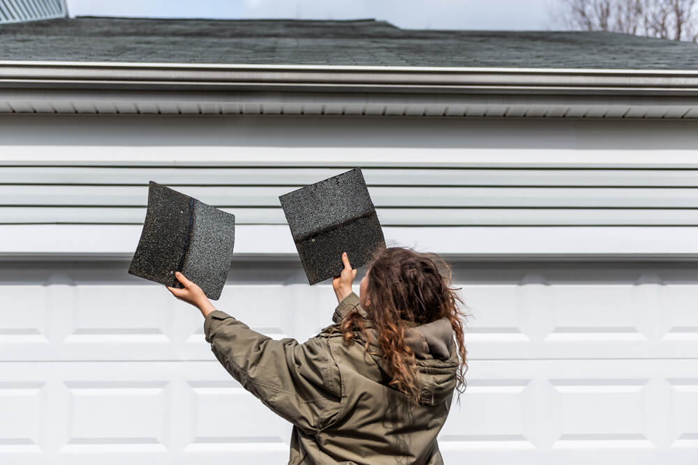 Homeowner holding up 2 roofing shingles